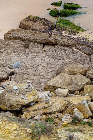 beach coastline with stones and sand in cloudy day
