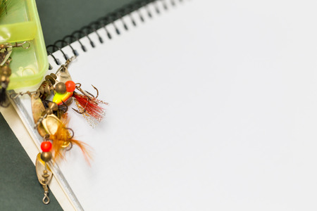 big notebook with fishing tackles on color paper background. outdoors activity sport and relaxの写真素材