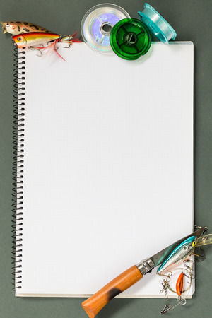 big notebook with fishing tackles on color paper background. outdoors activity sport and relaxの写真素材