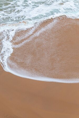 Ocean coast, moviment white foam on sand. Turquoise water. 