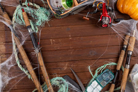 Fishing tacles on wooden background in Halloween designe with spaders and web. Mockap for advertisment and publishing.の写真素材