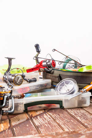 Different fishing tacles with rod and reels on wooden brown background. Mockap for advertisment and publishing.の写真素材
