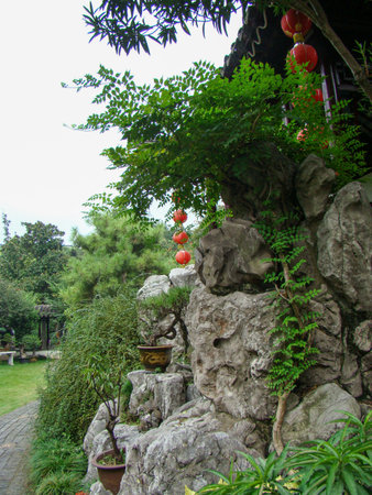 Stone garden with red lanterns and green plants in the park.の写真素材