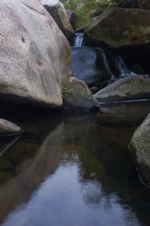 Waterfall in the forest with stones in the foreground, Thailand.の写真素材