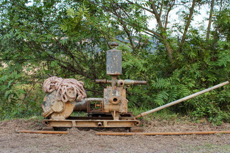 Old rusty water pump on the ground in the garden, Thailand.