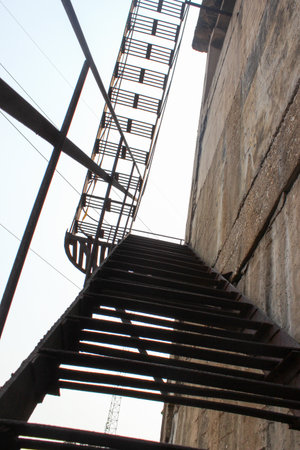 Old fire escape stairs in a building, closeup of photo.の写真素材