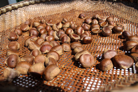 chestnuts in a basket on a market stall, closeup of photoの写真素材