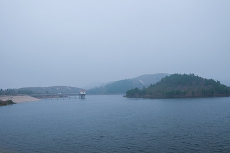 landscape view of a dam on a lake in the fog.の写真素材