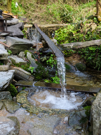 Water flowing from a well in the garden, close-up.の写真素材