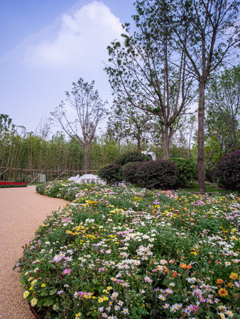 Colorful flower garden in the park with blue sky and white cloudsの写真素材