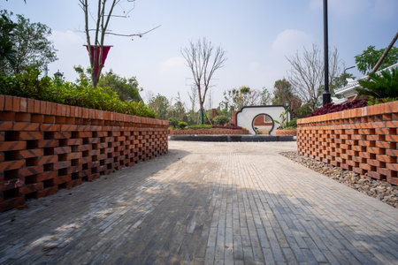 Outdoor walkway in the park with red brick wall, Thailand.