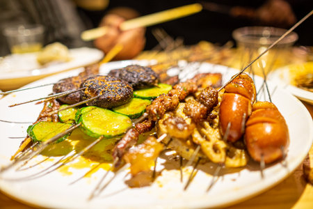 grilled meat and vegetables on skewers with sauce in a restaurant