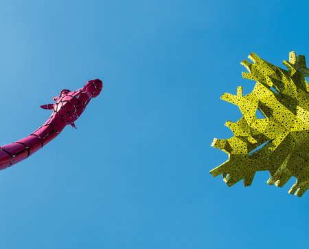 Wuhan, Hubei Province, China - September 22, 2019: A low angle detail of vibrant pink and yellow abstract sculptures reaching towards a clear blue sky in the Wuchang district.のeditorial素材