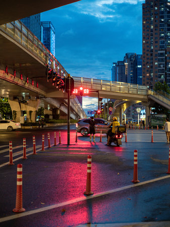 Wuhan, Hubei Province, China - July 28, 2024: Pink and red neon illumination reflected on a wet...