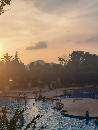 Wuhan, Hubei Province, China - May 30, 2023: The warm glow of the sunset sky is reflected in the...