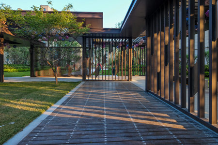 A landscape view from the side of a wooden gazebo, looking out across a stone-paved path into a...