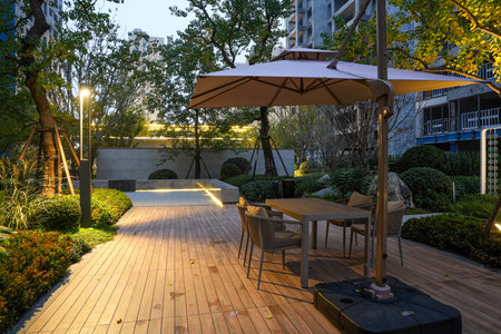 An inviting outdoor seating area with modern furniture, warmly lit against the backdrop of a quiet...