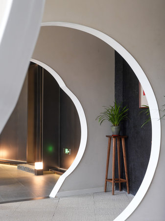 A modern curved archway framing an interior space with minimalist design and clean lines. The image...