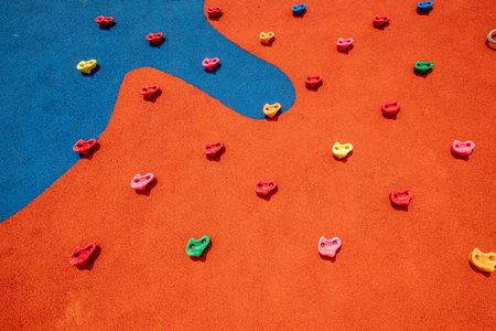 Description: A close-up of a colorful climbing wall designed for children in a modern playground....