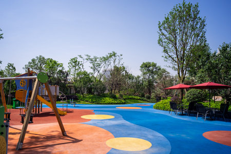 Description: A wide view of a modern playground with colorful rubber flooring and play equipment....
