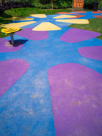 Description: A colorful, patterned rubber floor in a playground area, creating an abstract design. The image conveys modern texture, design, and playfulness. High-quality photography.の写真素材
