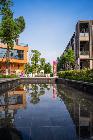 wuhan, china - may 16, 2016: the reflection of modern commercial buildings in a dark water pool in...