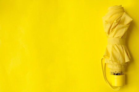 Umbrella on the right side of a yellow background, folded umbrellaの写真素材