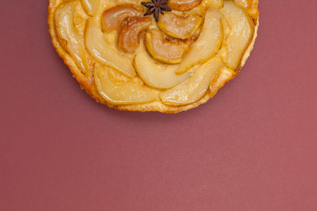Tarte Tatin apple and pear tart pie isolated on claret background with copy spaceの写真素材