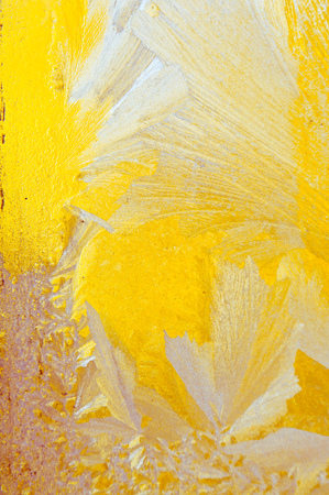 Melted and frosted ice pattern on frosty window glass in winterの写真素材