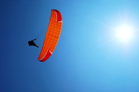 Paragliders fly with the sun behindの写真素材