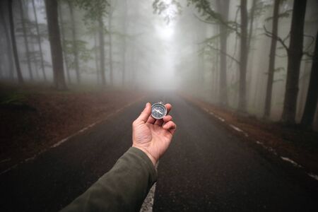 Traveler holding a compass. Hiker searching the right direction in the forest.の写真素材