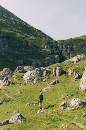 Hiking in the Carpathian mountains. female with backpack and trekking poles