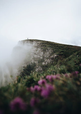 Hiker on top of a mountain in the fog. Beautiful landscape.の写真素材