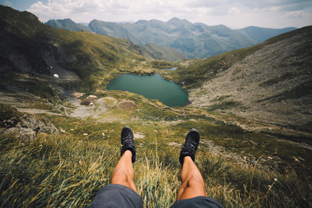 Hiking boots on top of a mountain in the background of a lake