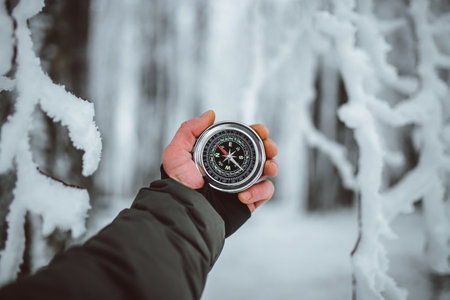 Compass in the hands of a man in the winter forest.の写真素材