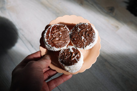 Chocolate muffins with cream in a plate on a wooden background