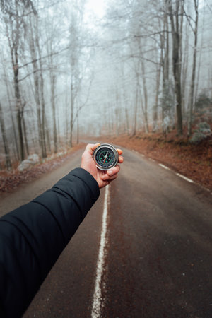 Traveler Male hand holding a compass in the foggy forestの写真素材