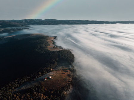Aerial view of foggy morning landscape with rainbow in the skyの写真素材
