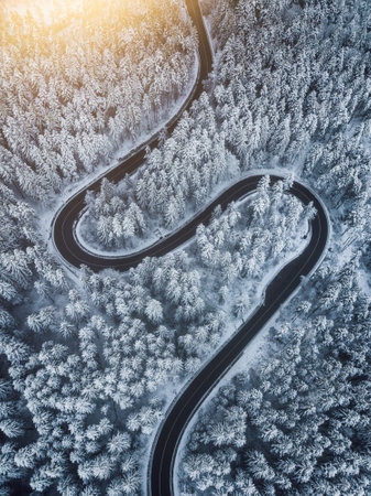 Aerial view of a winding road in the winter forest. Top viewの写真素材