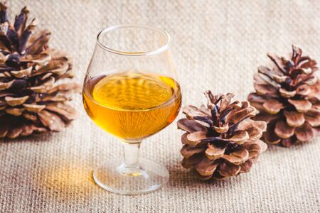 Christmas brandy glass on linen fabric background. Party rustic alcohol backdrop.の写真素材