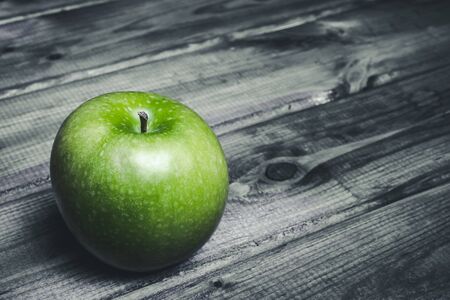 Green apple on grunge black wooden table.の写真素材