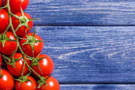 Cherry tomatoes on blue painted grunge wooden table.の写真素材