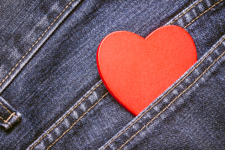Red wooden heart hidden in pocket.の写真素材
