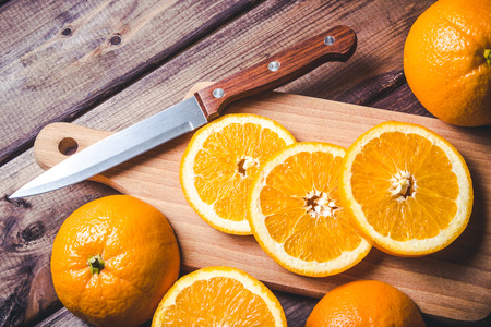 Orange slices and knife on wooden table.の写真素材
