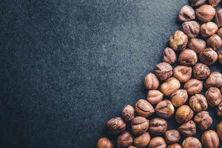 Hazelnuts isolated on black surface background.