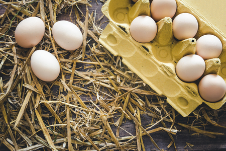 Raw eggs in box on background
