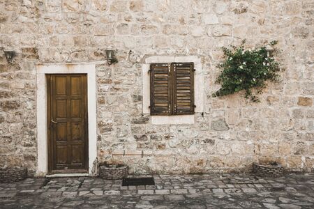 Wooden door and window. Old town brick wall house.の写真素材