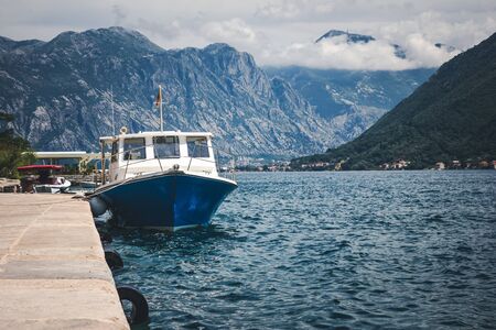 Boat on the water of the Adriatic sea in Kotor bay with mountain in the background.の写真素材