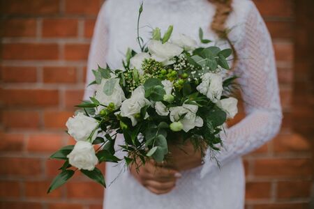Bride in white dress holding bouquet of white flowers.の写真素材