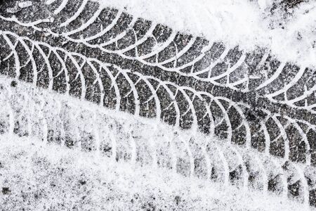 Snow tyre mark on aphalt pattern background.